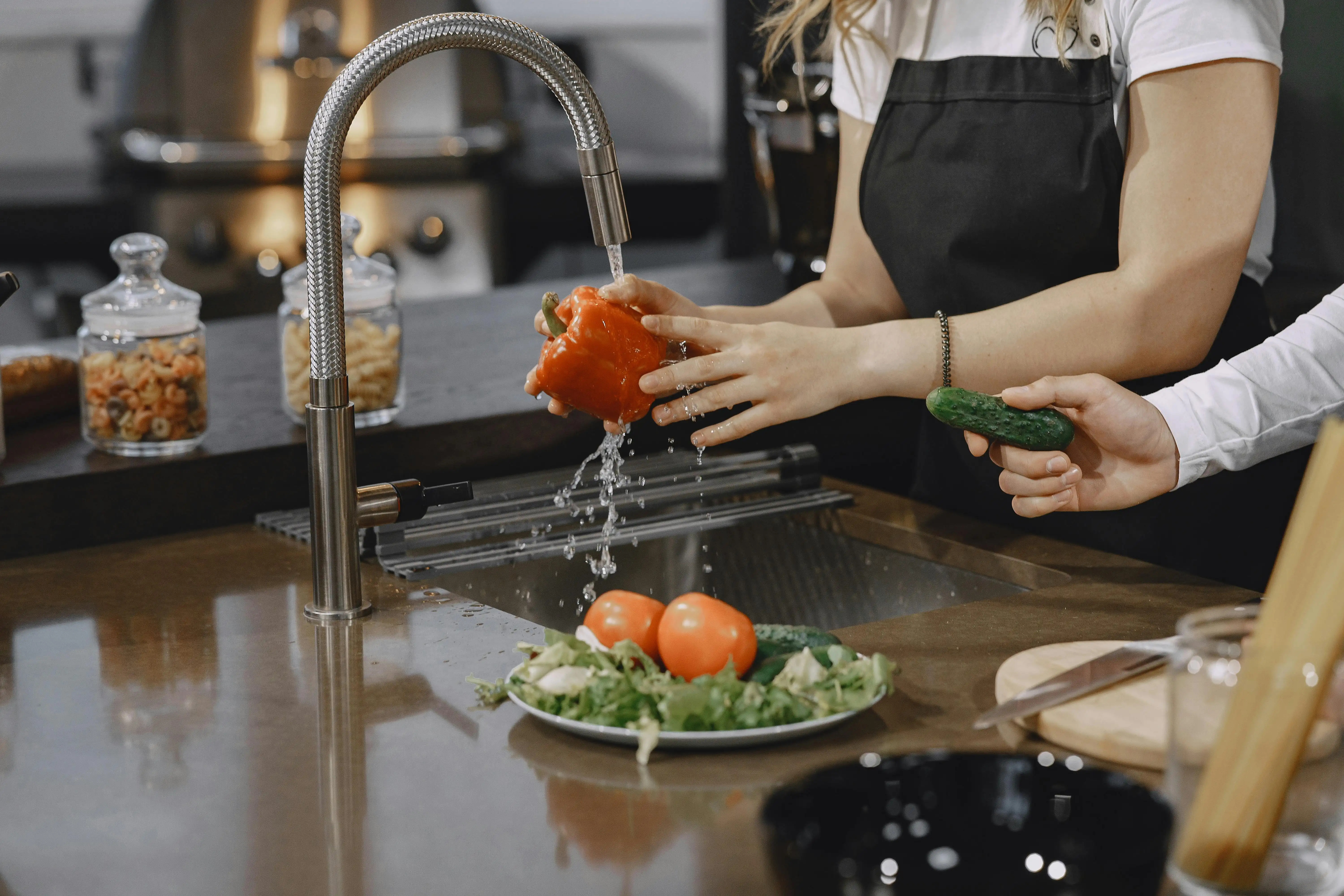 Woman washing vegetables in pure filtered kitchen water - Water Fixers of DFW